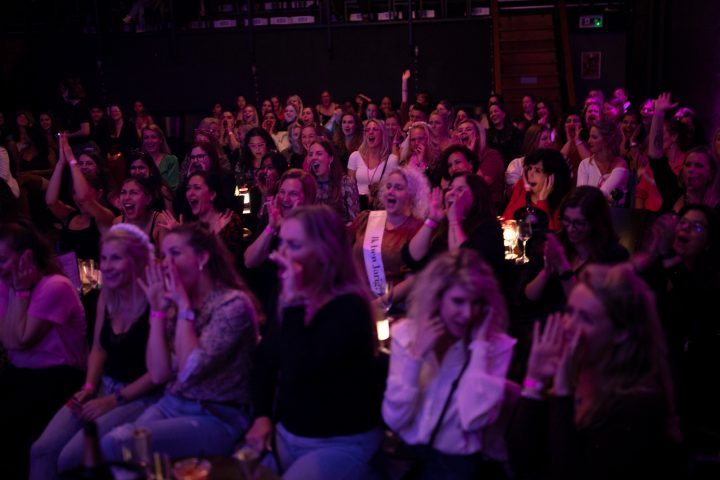 large group of people sitting in a dark room